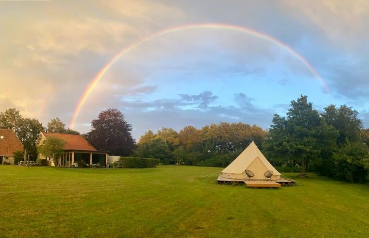 Vakantiehuis in De Hoeve, gelegen op het Friese platteland, met regenboog boven de natuur.
