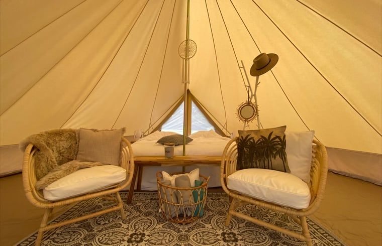 Binnenruimte van Vakantiehuis in De Hoeve, Friesland, gezellig ingericht met rieten stoelen.