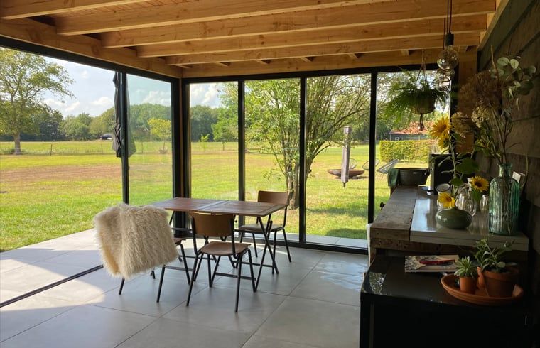 Eetruimte met uitzicht op de natuur in Vakantiehuis in De Hoeve, Friesland.