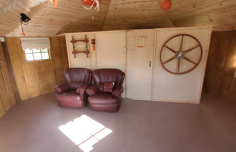 Gezellige binnenruimte van Vakantiehuisje in Jislum met comfortabele stoelen, ideaal voor ontspanning in Friesland.