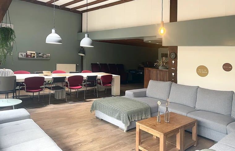 Picknickplatz am Ferienhaus in Hegebeintum, ruhige Umgebung mit gruenem Gras und Baeumen.