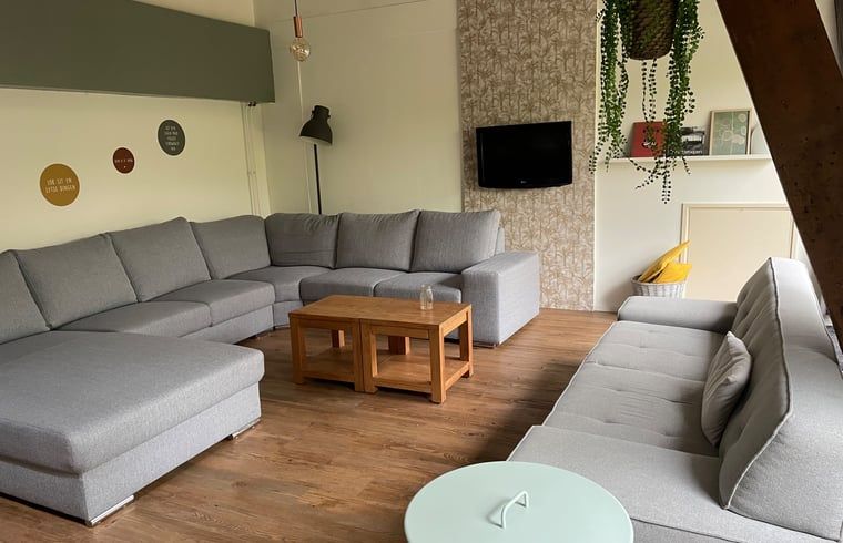 Geraeumiger Flur im Ferienhaus in Hegebeintum, Friesland, mit Holzvertaefelung und Fliesenboden.