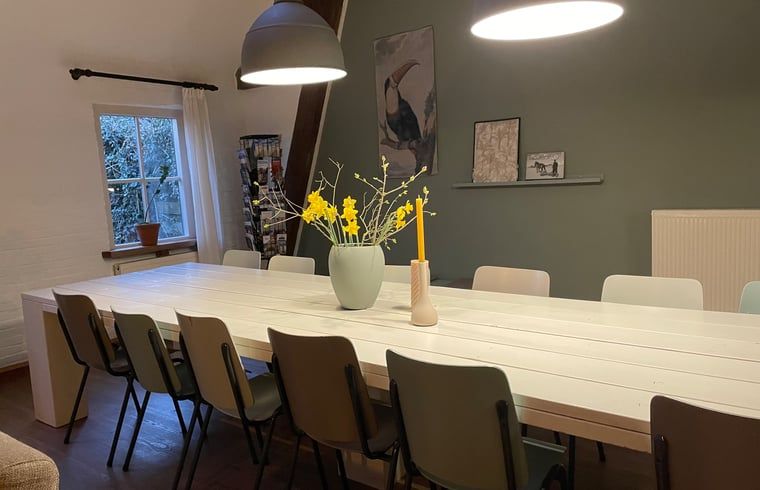 Helles Esszimmer im Ferienhaus in Hegebeintum, mit langem Tisch und Gartenblick in Friesland.