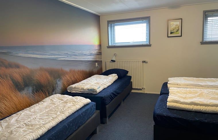 Schlafzimmer mit Wanddekoration im Ferienhaus in Hegebeintum, mit Blick auf die friesische Landschaft.