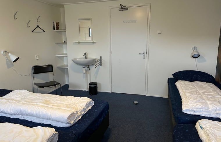 Geraeumiges Schlafzimmer mit mehreren Betten im Ferienhaus in Hegebeintum, Friesland, fuer Familien.