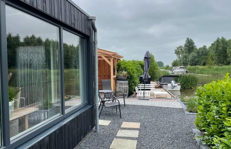 Moderne buitenruimte van Vakantiehuisje in Bartlehiem met uitzicht op het kanaal in Friesland.