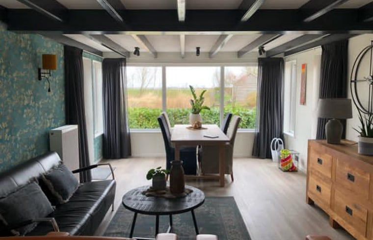 Gezellige woonkamer van Vakantiehuisje in Bartlehiem met grote ramen en landelijke inrichting.