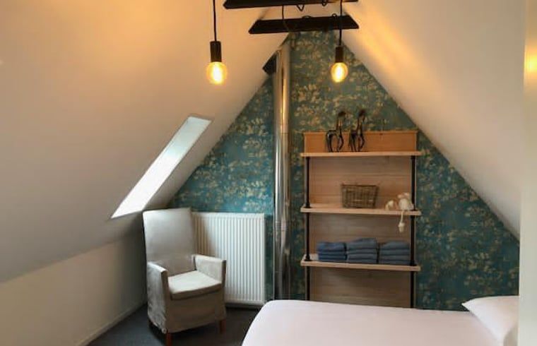 Knusse zolderkamer in Vakantiehuisje in Bartlehiem met dakraam en comfortabele fauteuil.