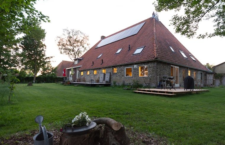 Cottage in Echten, ein charmantes Ferienhaus in der friesischen Landschaft in Friesland, umgeben von einem gruenen Garten und rustikaler Architektur.