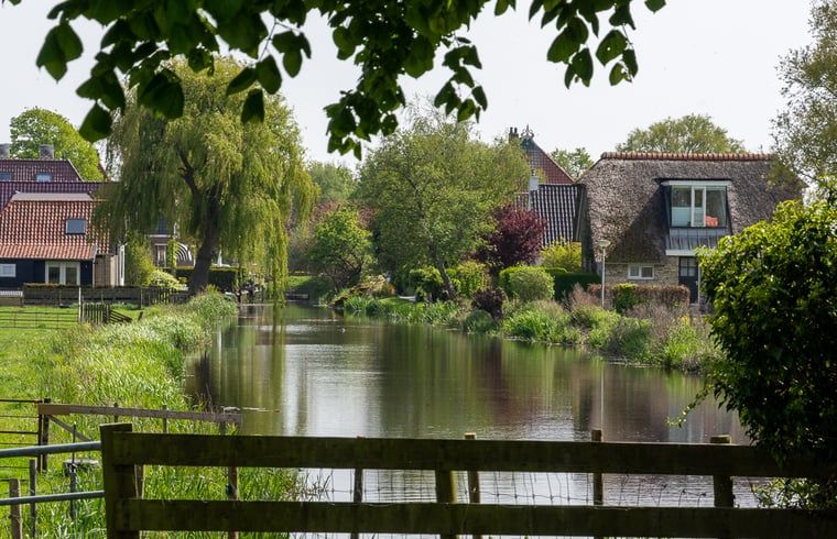 Rustikales Cottage in Echten, ein Ferienhaus in der friesischen Landschaft, umgeben von gruener Natur und einem ruhigen Wasserlauf.