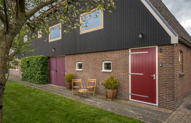 Huisje in Bears, een charmant vakantiehuis op het Friese platteland, met een uitnodigend terras en landelijke architectuur in Friesland.
