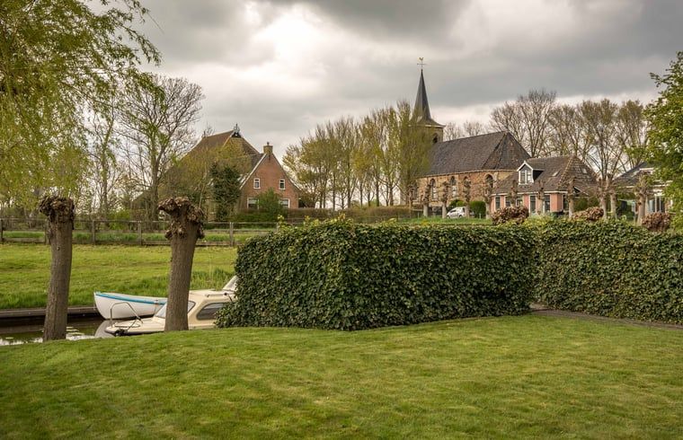 Geniet van de rust op het terras van Huisje in Bears, gelegen op het Friese platteland in Friesland, omringd door groene natuur.