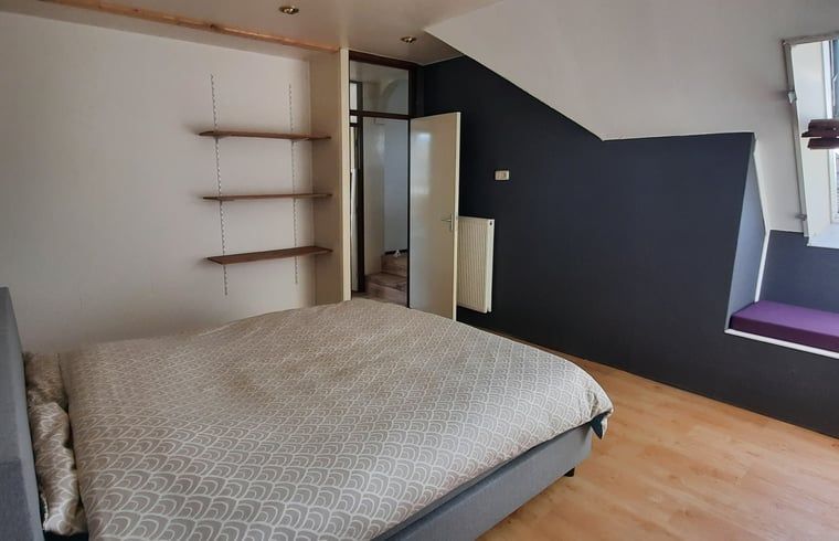 Gemuetliches Schlafzimmer in einem Ferienhaus in Oldelamer, Friesland, mit Dachfenster und Holzinterieur, ideal fuer einen entspannten Aufenthalt auf dem friesischen Land.