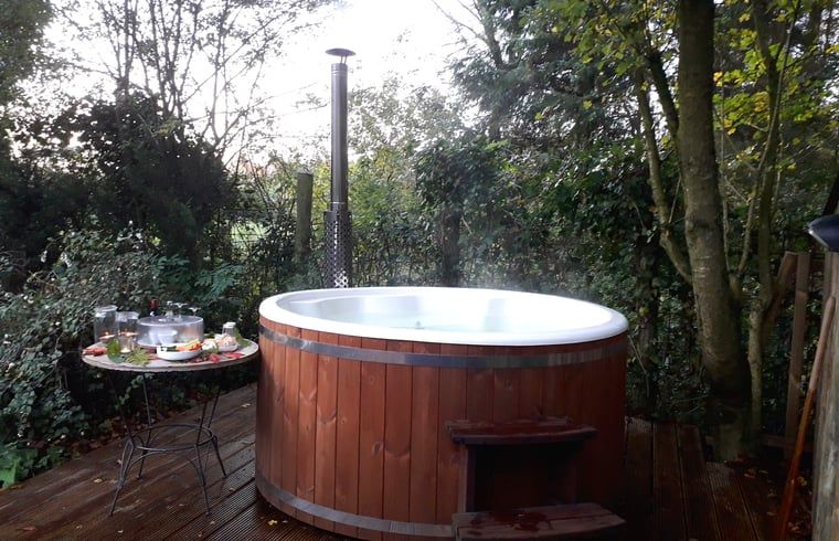 Bubbelende hot tub in de tuin van Huisje in Twijzelerheide, vakantiehuis in Friesland voor luxe relaxen.