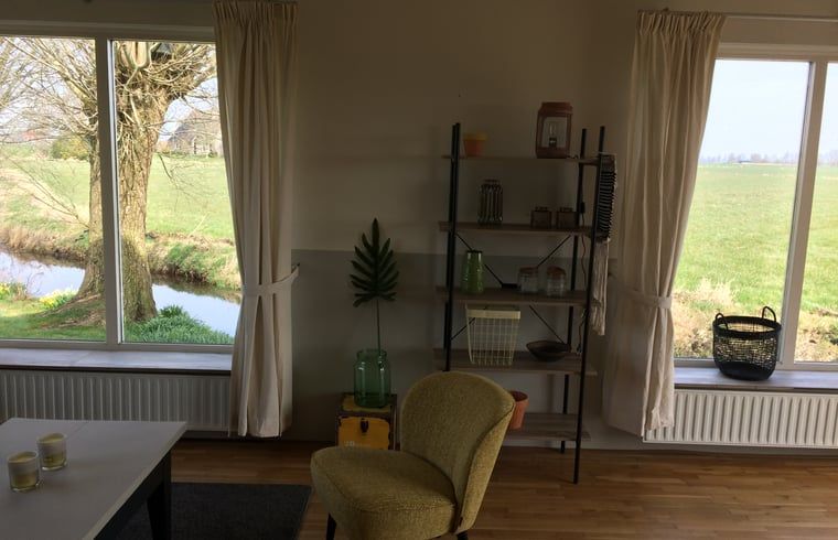Helles Wohnzimmer mit Blick auf die Natur im Ferienhaus in Nes, Friesland, ideal fuer Erholung.