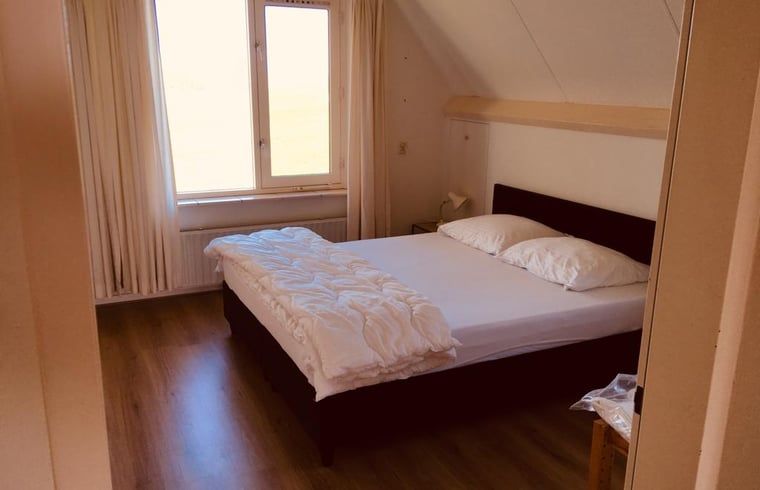 Schlafzimmer mit Doppelbett im Ferienhaus in Nes, Friesland, fuer eine angenehme Nachtruhe.