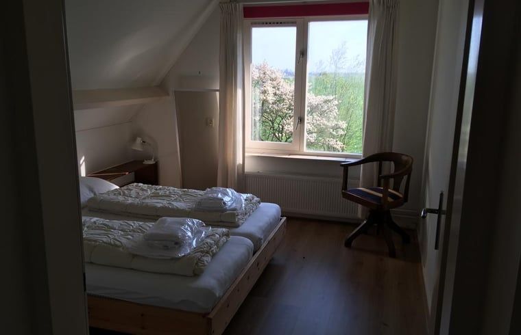 Geraeumiges Schlafzimmer mit Blick auf den Garten im Ferienhaus in Nes, Friesland.