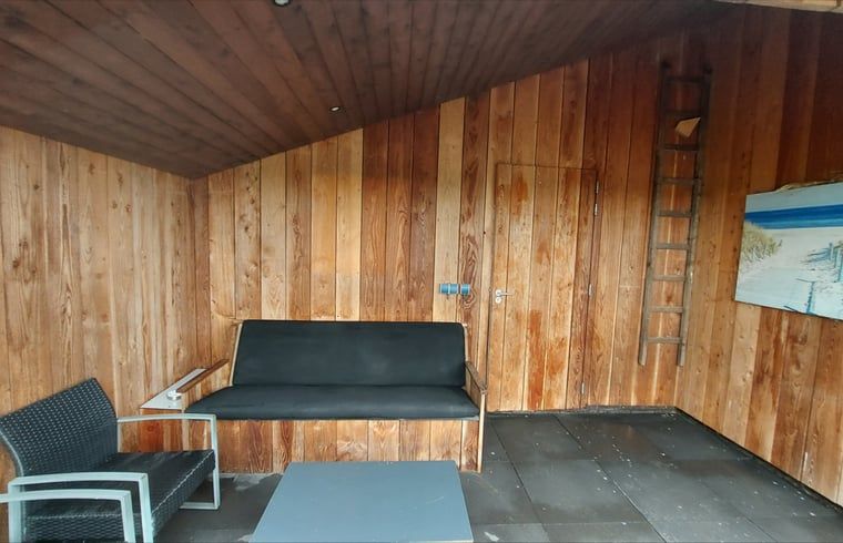 Wooden veranda with seating at Cottage in Jannum near Dokkum, ideal for relaxation in Friesland.