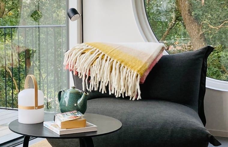 Gemuetliche Sitzecke im Ferienhaus in Arnheim mit Blick auf die Natur.