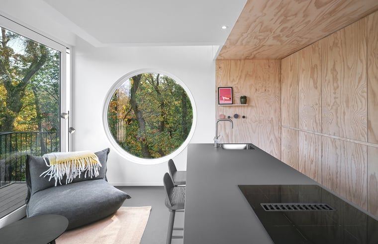 Kueche und Sitzecke im Ferienhaus in Arnheim mit Blick auf das gruene Rivierengebied.