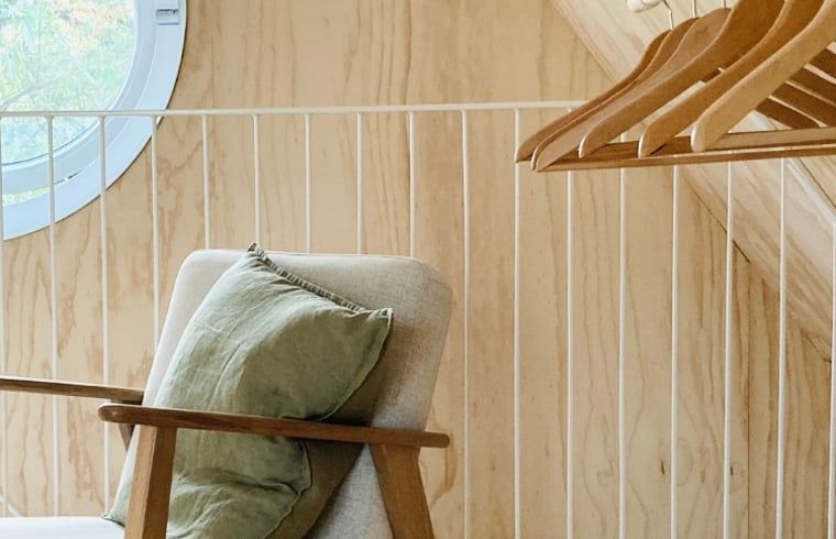 Detail eines Schlafzimmers in einem Ferienhaus in Arnheim mit Holzverkleidung und Haengeleuchten.