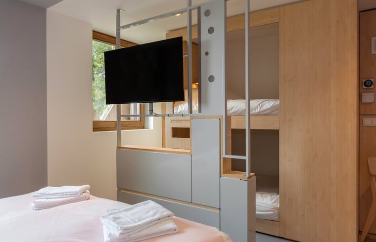 Schlafzimmer mit TV und Etagenbett in Cottage in Arnhem, Ferienhaus.