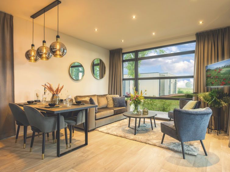 Moderne woonkamer in Vakantiehuis MarinaPark Bad Nederrijn, Maurik, Gelderland, met grote ramen en stijlvolle inrichting.