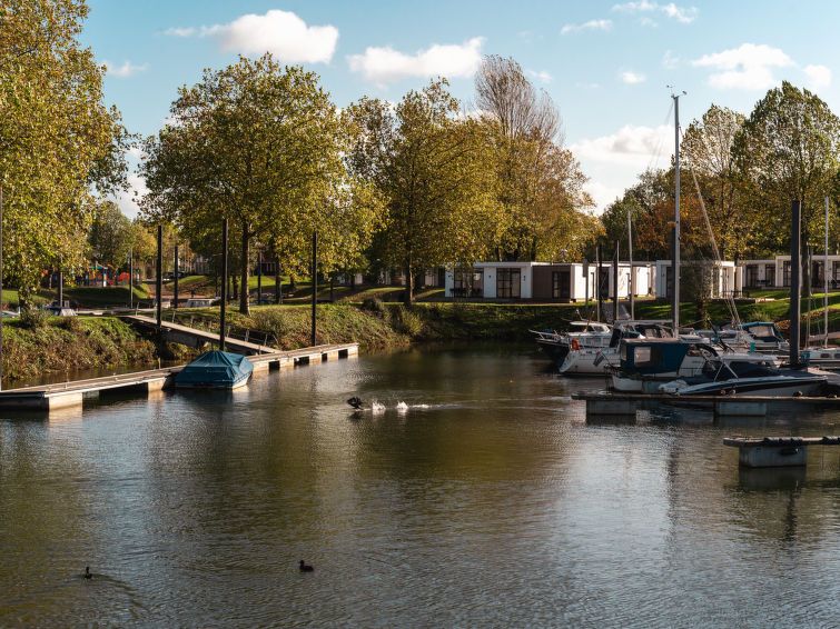 Rustige waterkant bij Vakantiehuis MarinaPark Bad Nederrijn, Maurik, Gelderland, met boten en groene omgeving.