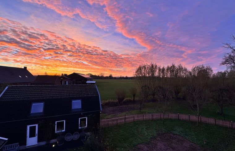 Adembenemende zonsondergang bij Huisje in Acquoy, vakantiehuis in het Rivierengebied, Gelderland, met uitzicht op het schilderachtige landschap.