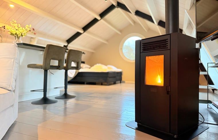 Gezellige binnenruimte van Huisje in Acquoy, vakantiehuis in Rivierengebied, Gelderland, met knusse houtkachel en comfortabele zithoek.