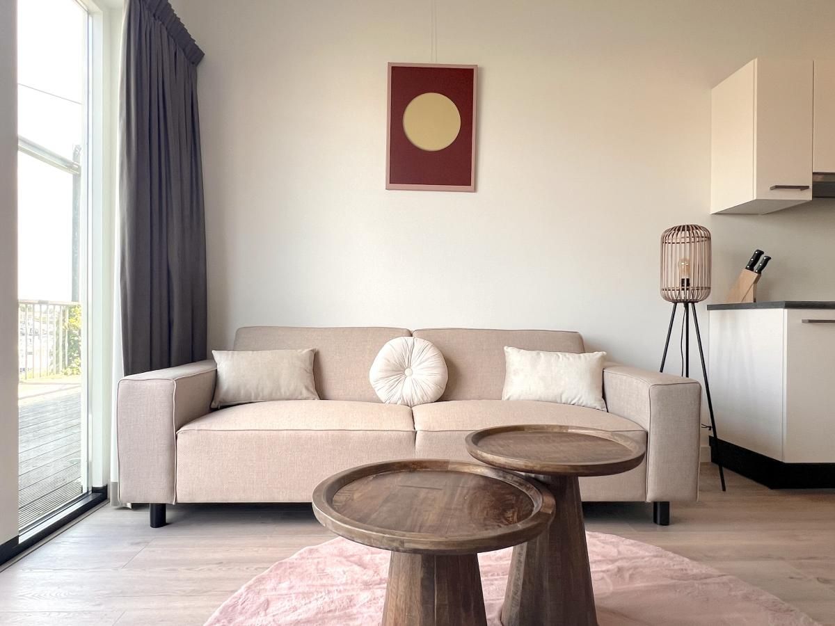 Stilvolles Wohnzimmer im Ferienhaus Havenzicht, Maasbommel, mit bequemem Sofa und moderner Einrichtung in Gelderland.