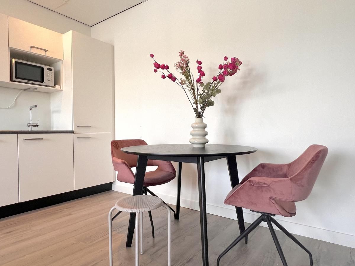 Gemuetliche Essecke mit Blumen auf dem Tisch im Ferienhaus Havenzicht, Maasbommel, Rivierengebied, Gelderland.