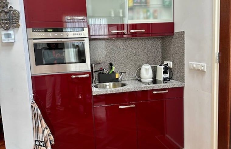 Compacte keuken in Vakantiehuis in Angerlo, Gelderland met stijlvolle rode kasten.