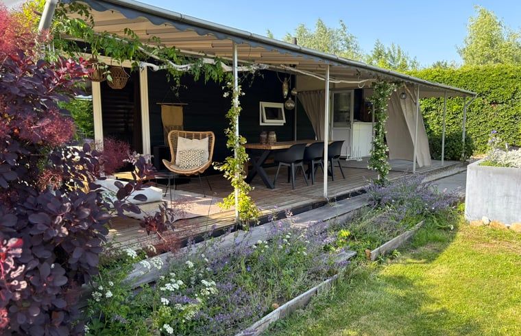 Geniet van de rust op de veranda van Huisje in Gellicum, een charmant vakantiehuis in het groene Rivierengebied, Gelderland.