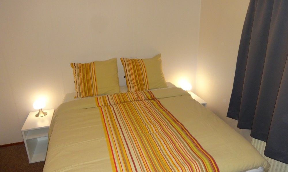 Sfeervolle slaapkamer in Boshuisje 'de Wielewaal', een vakantiehuis in Winterswijk, Achterhoek, Gelderland, met comfortabel tweepersoonsbed.