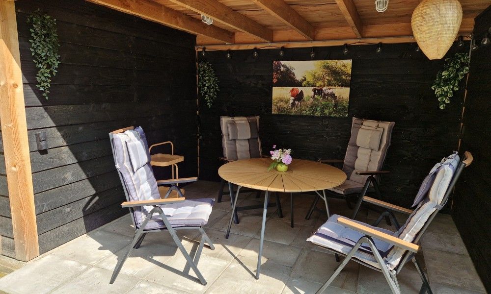 Gezellige veranda van Boshuisje 'de Wielewaal' in Winterswijk, Achterhoek. Ontspannen buitenruimte in vakantiehuis Gelderland.