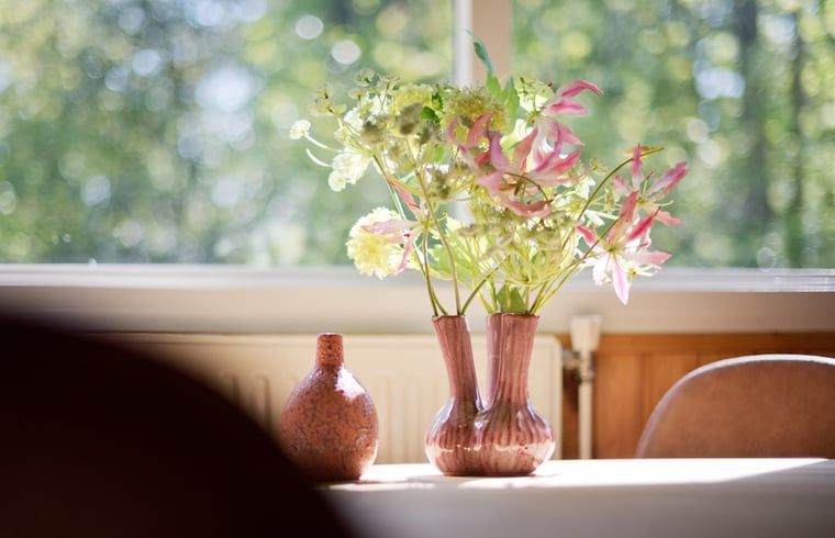 Vaas met bloemen in de eetkamer van Vakantiehuisje in Winterswijk, Achterhoek.