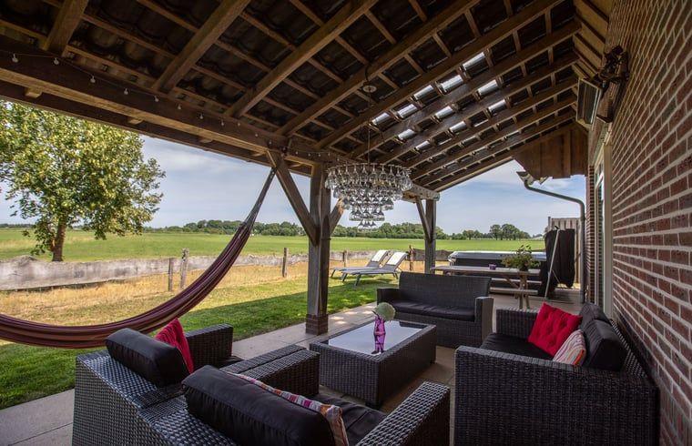Overdekte veranda bij Vakantiehuis in Zelhem met comfortabele zitplaatsen, Achterhoek, Gelderland.