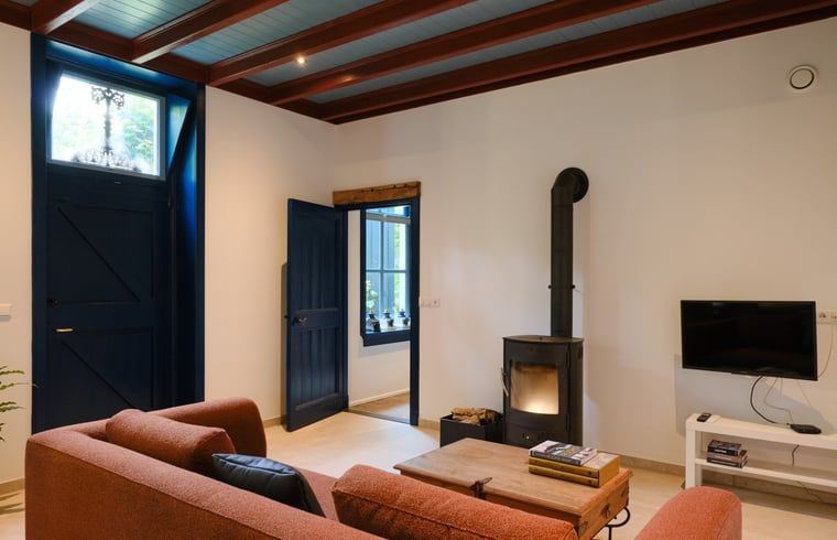 Gemuetliches Wohnzimmer im Ferienhaus in Zelhem, Achterhoek, mit Holzofen und bequemem Sofa fuer einen entspannten Aufenthalt in Gelderland.