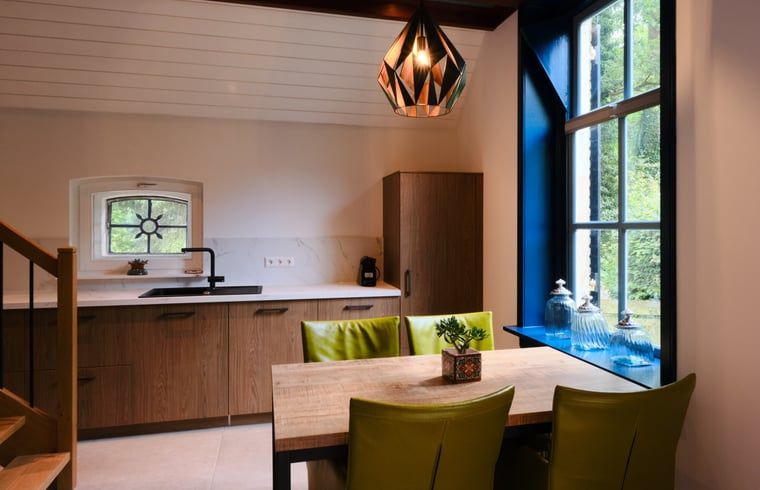 Moderne Kueche im Ferienhaus in Zelhem, Achterhoek, Gelderland mit Holzinterieur und Blick auf die gruene Umgebung.