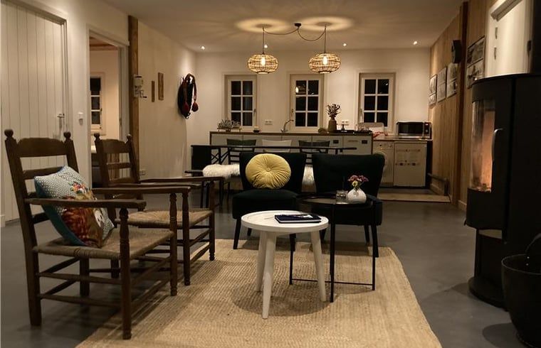 Atmospheric evening lighting in the living room of Huisje in Westendorp, bed and breakfast in the Achterhoek, with warm decor.