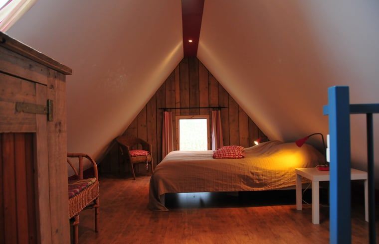 Gezellige slaapkamer in Vakantiehuis in Aalten, Achterhoek, Gelderland, met houten interieur en knusse sfeer.