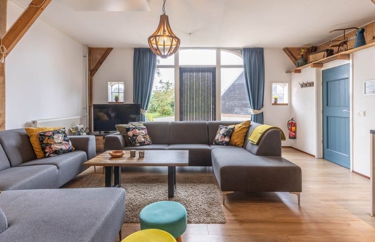 Gezellige woonkamer in Huisje in Aalten, vakantiehuis in de Achterhoek, met comfortabele banken en landelijke uitstraling.