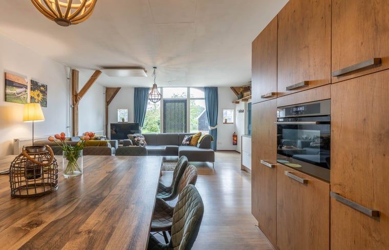 Moderne keuken en eetruimte in Huisje in Aalten, vakantiehuis in de Achterhoek, ideaal voor gezellige maaltijden.