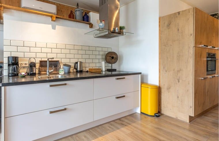 Moderne keuken in Huisje in Aalten, vakantiehuis in de Achterhoek, met strakke witte kasten en apparatuur.