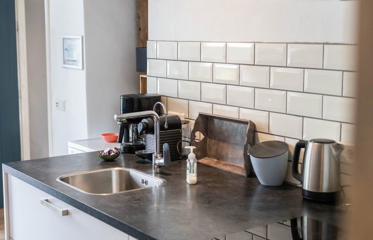 Keukenhoek in Huisje in Aalten, vakantiehuis in de Achterhoek, met koffiezetapparaat en stijlvolle tegels.