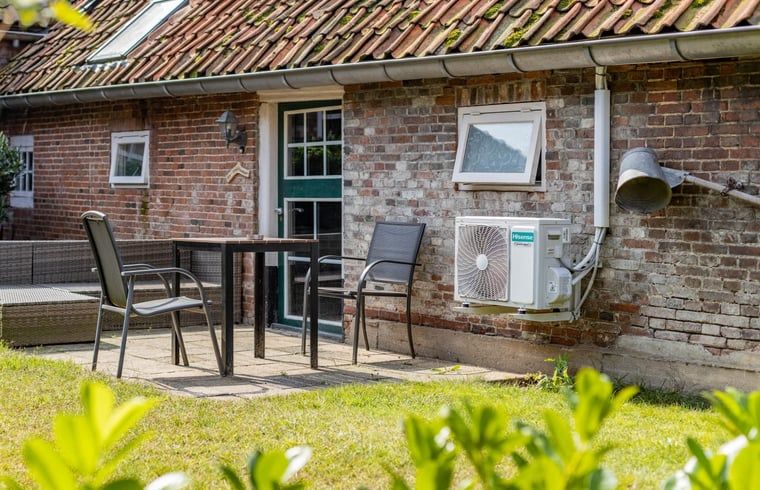 Terras van Huisje in Aalten, vakantiehuis in de Achterhoek, met zitgelegenheid en uitzicht op de tuin.