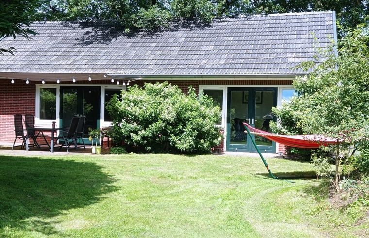 Relax in the charming Huisje in Aalten, a vacation home in the Achterhoek region of Gelderland, with an inviting terrace and green garden.