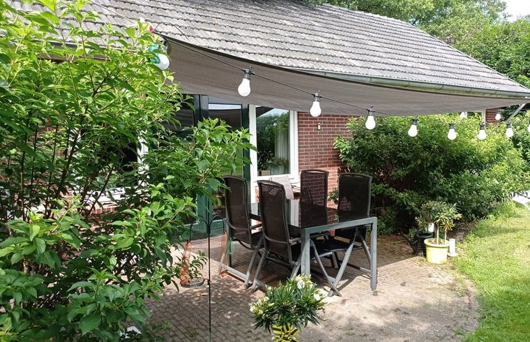 Enjoy the green surroundings on the terrace of Huisje in Aalten, a charming vacation home in the Achterhoek region of Gelderland.