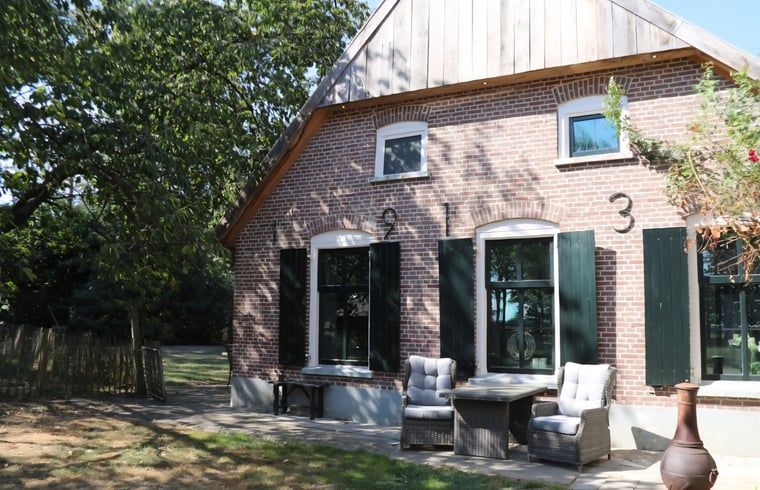 Aussenansicht des Ferienhauses in Vragender, Achterhoek, mit schoener Terrasse und gruener Umgebung.